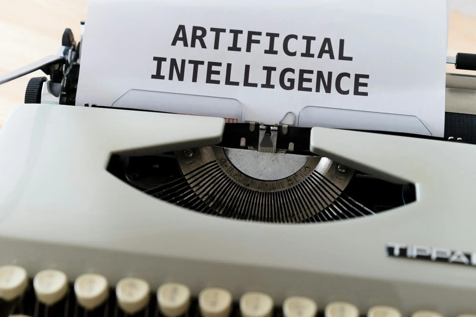 A white Tippa typewriter with "Artificial Intelligence" typed on paper, AI writing and publishing