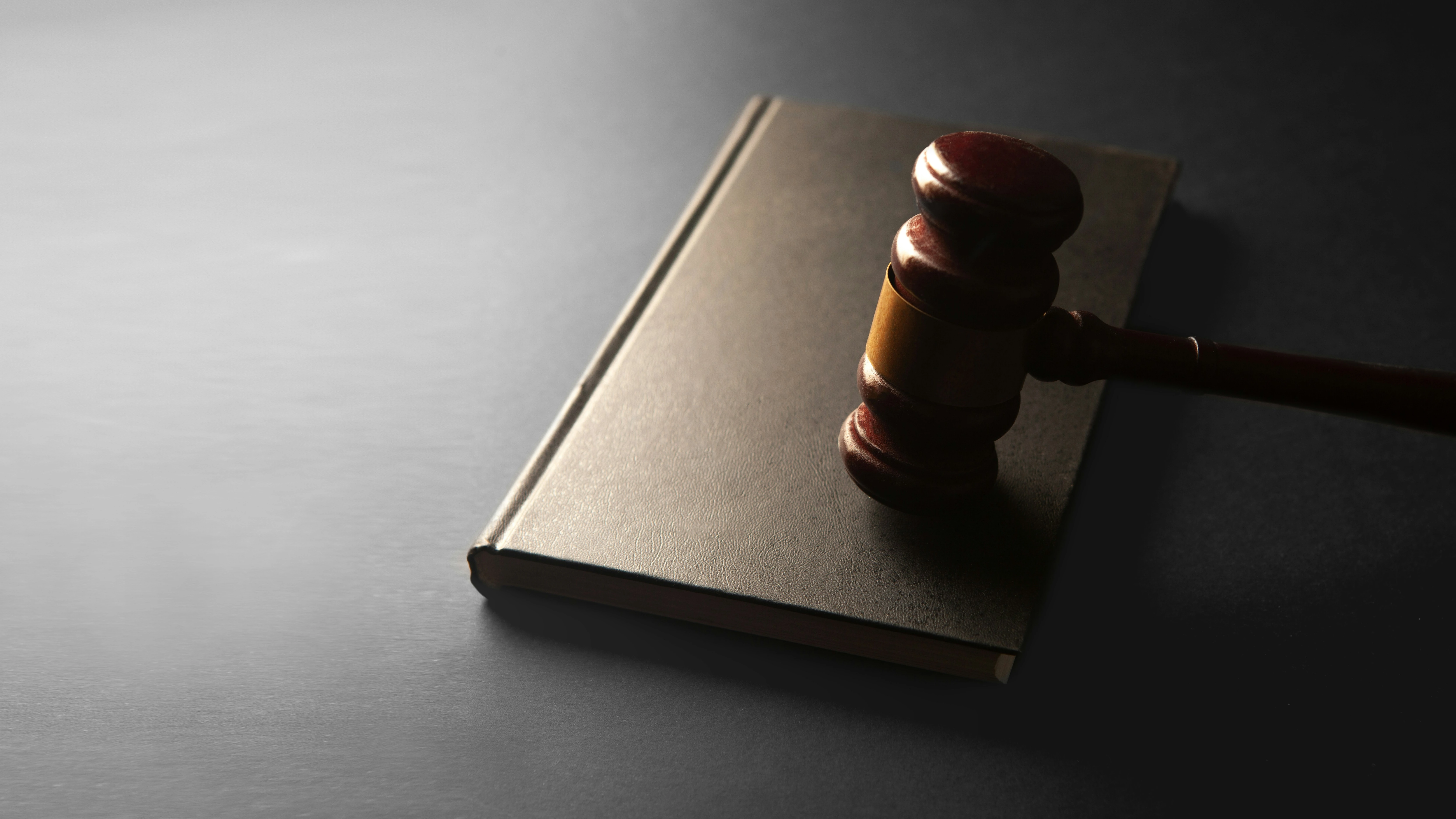 A wooden gavel resting on a closed book, representing the class action lawsuit against Google